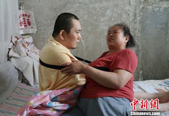 身體日漸衰老的梁青蘭每次幫兒子翻身、坐立，全身的衣物都要濕透一次?！∩忻鱾b 攝