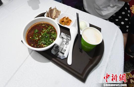 圖為&ldquo;環(huán)西部火車游Y667/8次&rdquo;列車上推出蘭州牛肉面套餐，套餐38元，有一碗牛肉面、一碟牛肉、一個(gè)雞蛋、一份小菜、一份甜胚子。　楊艷敏 攝