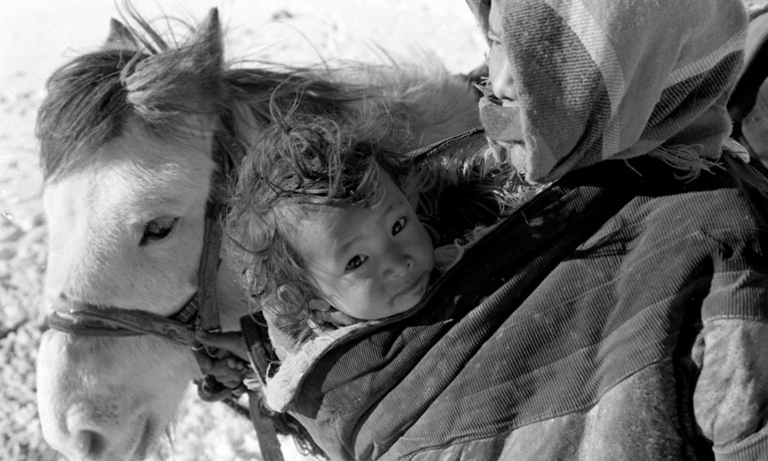 1990年3月，西藏當(dāng)雄縣納木湖鄉(xiāng)三村女牧民斯卓不畏嚴(yán)寒，懷抱幼子，準(zhǔn)備到遠(yuǎn)處放牧。新華社記者覺果攝