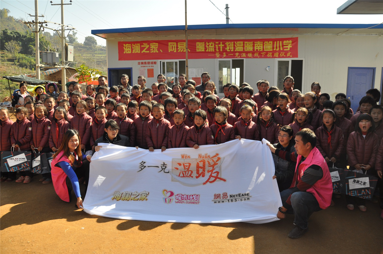 2014年11月20日，&ldquo;多一克溫暖&rdquo;公益團隊來到8.3大地震的重災區(qū)&mdash;&mdash;云南省昭通市魯甸縣的南筐小學。越過崎嶇山路，將一批又一批暖心羽絨服送到了師生們的手中，也將社會的關懷和愛意傳遞給了這些可愛的人。