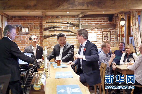 這是會晤結束后，習近平在卡梅倫陪同下乘車前往當?shù)匦℃?zhèn)體驗酒吧文化。新華社記者 鞠鵬 攝